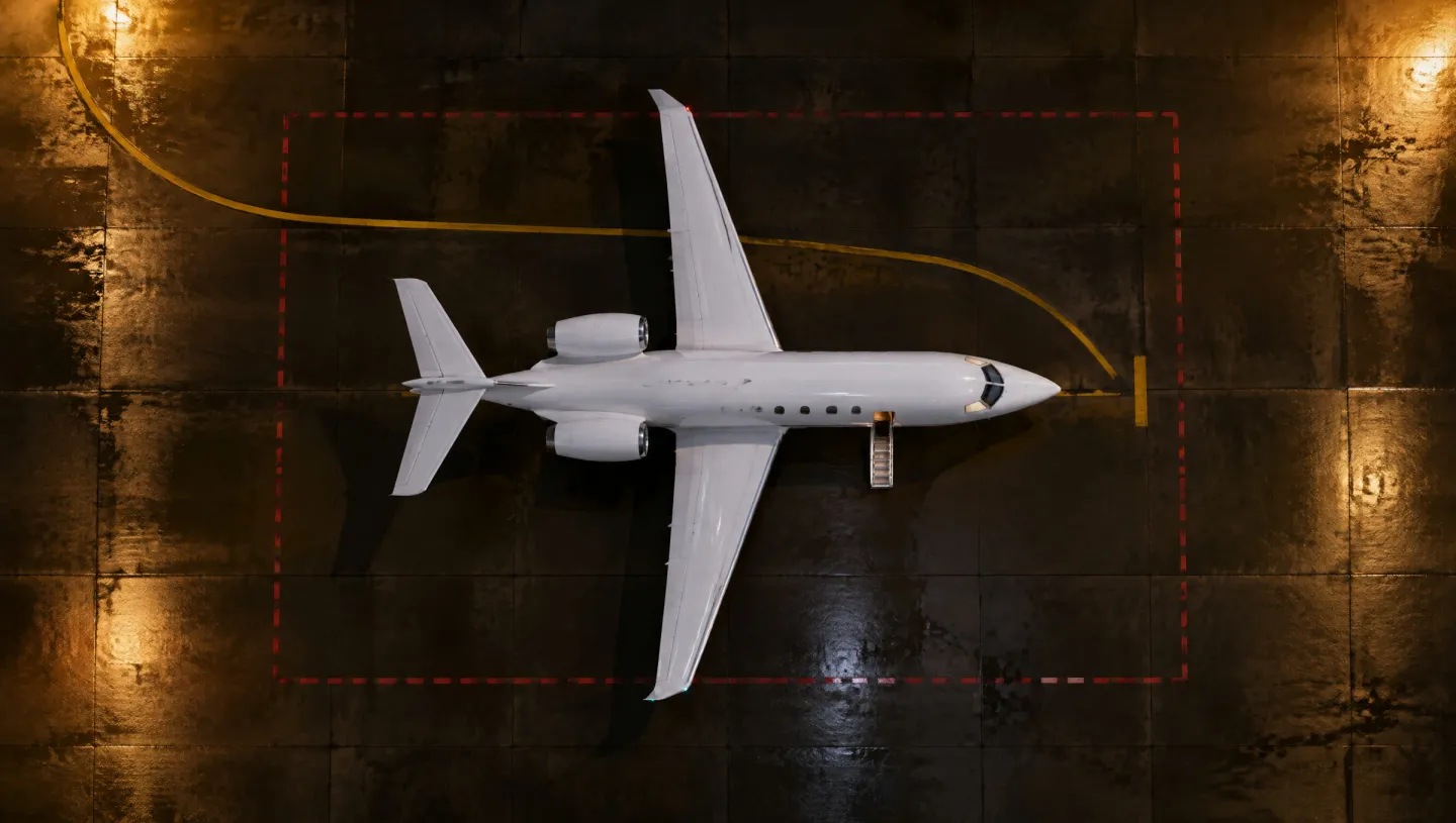 Night aerial view of an aircraft stand with a business jet parked in the centre